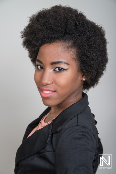 A Young Woman Poses Confidently With an Elegant Hairstyle in a Studio Setting, Showcasing Her Vibrant Personality and Stylish Attire During a Photoshoot