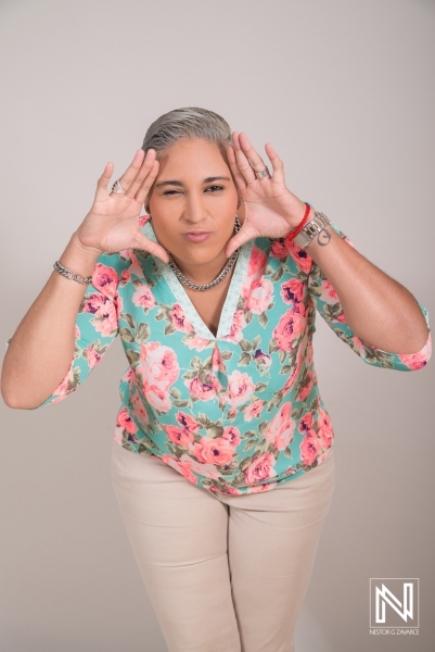 Woman Expressing a Playful Gesture While Wearing Floral Attire in a Light Studio Setting During a Creative Portrait Session