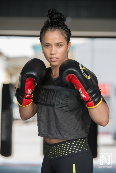 Boxer Training in a Gym, Wearing Red Gloves and Focused on Her Technique While Preparing for an Upcoming Match