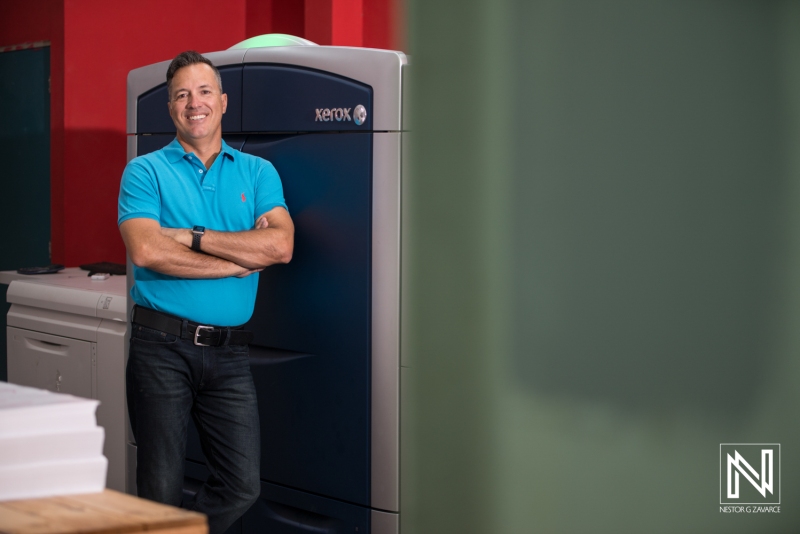 A Professional Standing Confidently Next to a High-Tech Printing Machine in a Modern Workspace, Showcasing Innovation and Engagement in Printing Technology