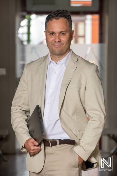 Confident Professional in a Light Beige Suit Holds a Portfolio in a Modern Office Environment During Daylight Hours