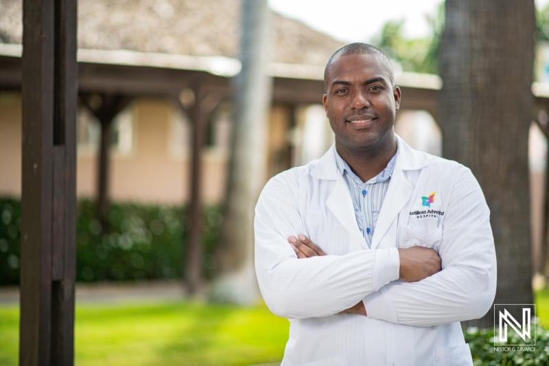 A Confident Healthcare Professional Stands Outdoors in a Medical Coat, Showcasing Dedication to Patient Care at a Health Facility in a Sunny Location