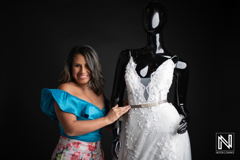 A Woman Joyfully Fits a Bridal Gown on a Mannequin in a Fashion Studio, Showcasing Intricate Details and Personal Style Choices