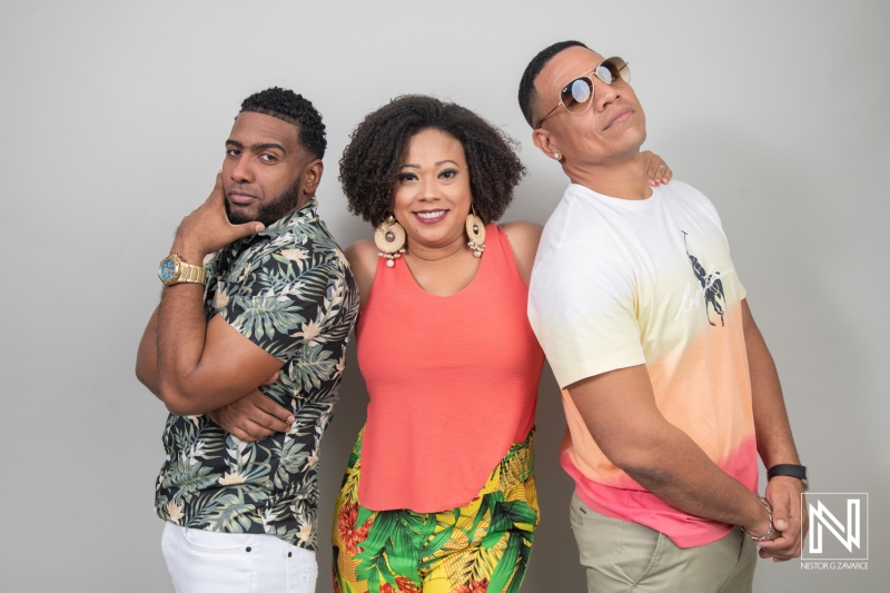 Three Friends Pose for a Cheerful Group Portrait Against a Neutral Backdrop Showcasing Vibrant Summer Outfits, Highlighting Their Lively Expressions and Camaraderie