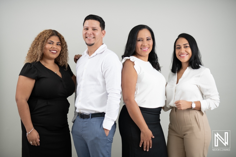 Group of Four Professionals Posing Together in a Modern Studio Setting During Daylight, Showcasing a Collaborative Spirit and Diverse Backgrounds