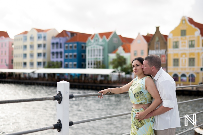 Couple Enjoying a Romantic Moment by the Water in a Vibrant Waterfront Area With Colorful Buildings in the Background During a Sunny Day