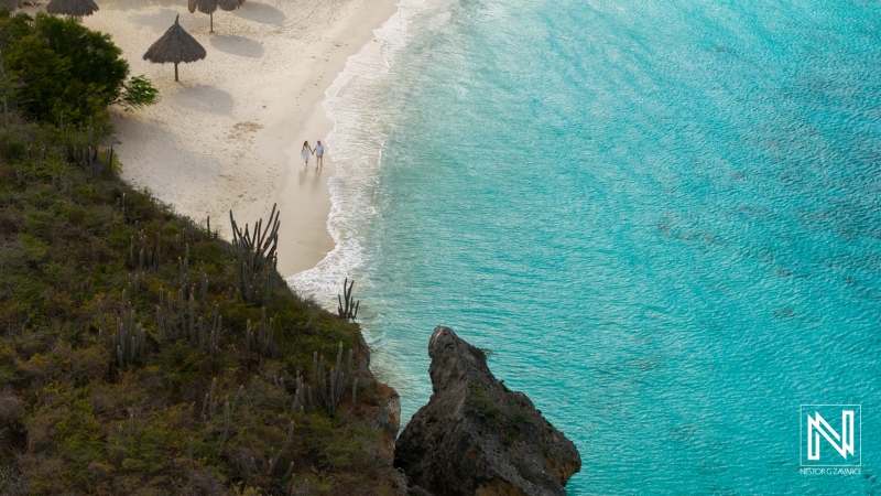 Couple enjoys a romantic sunrise stroll on the sandy shores of Cas Abao Beach in Curacao