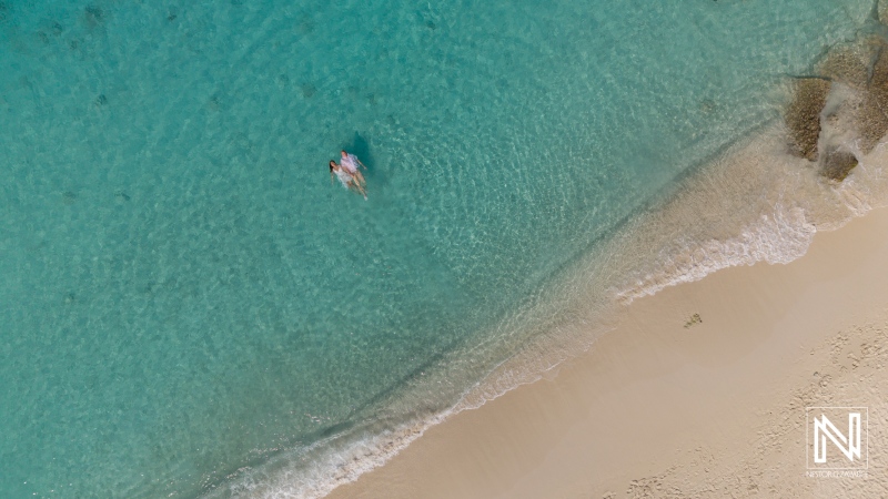 Couple enjoying a romantic sunrise moment at Cas Abao Beach, Curacao, embracing tranquility and love in a picturesque coastal setting