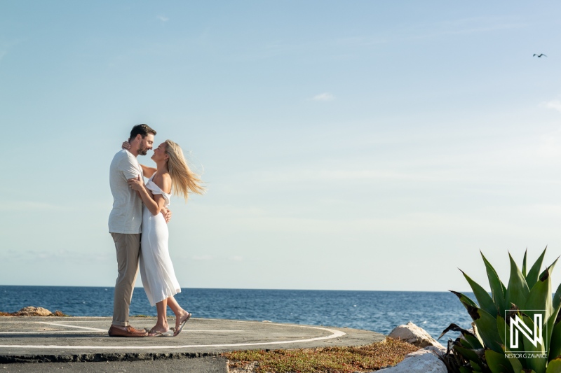 Couple enjoying a romantic moment by the ocean at Baoase Luxury Resort in Curacao during a sunny day