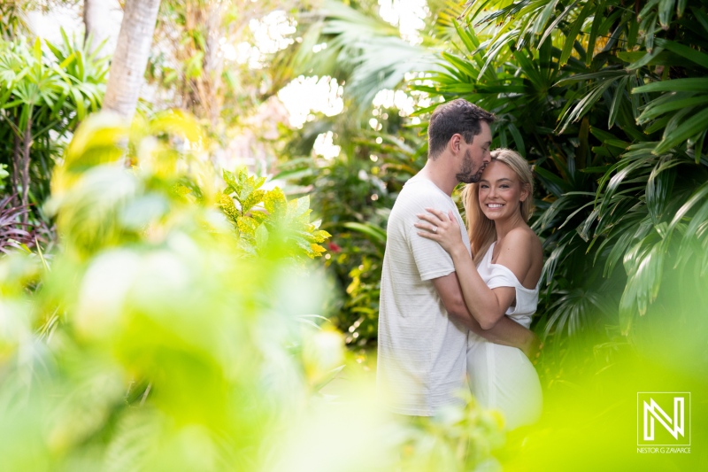 Couple embraces in lush greenery at Baoase Luxury Resort in Curacao during a romantic getaway