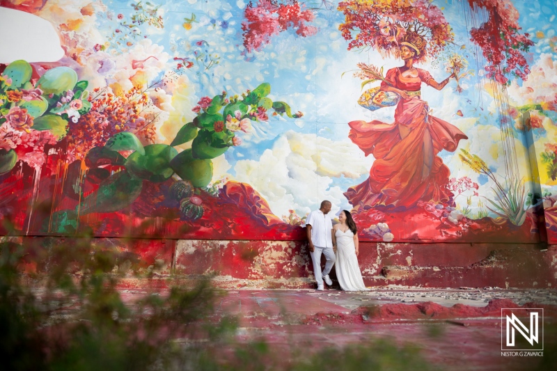 Couple enjoying a romantic moment in front of vibrant mural in Curacao during sunny afternoon