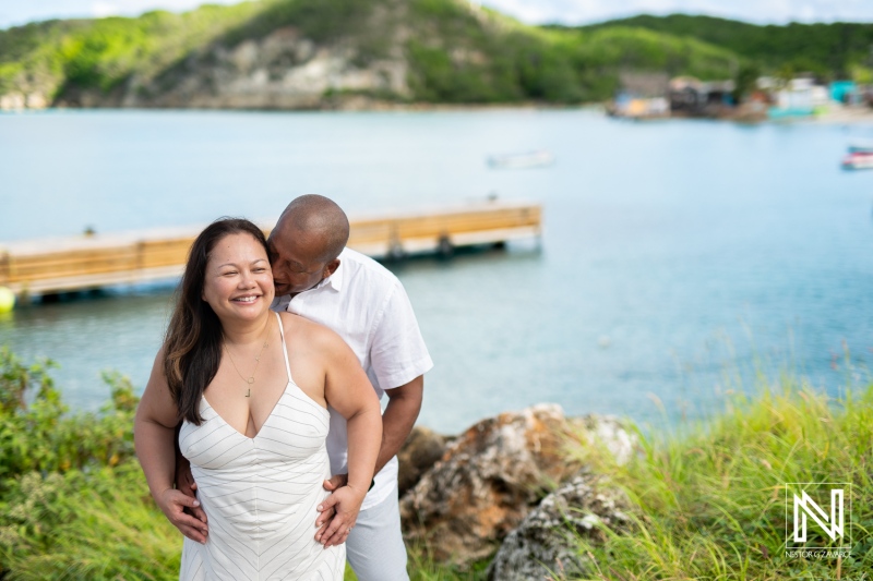 Couple enjoying a romantic moment by the tranquil waters of Curacao during a sunny day