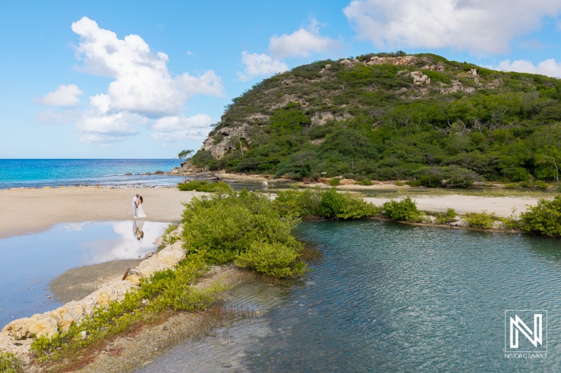 Couple enjoys a romantic moment on the tranquil shores of Curacao as they explore the beautiful coastal landscape