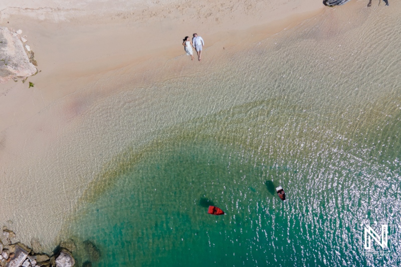 Couple enjoys a romantic moment on the serene beach of Baoase Luxury Resort in Curacao during a sunny day