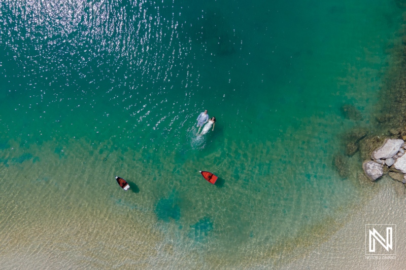 Couple enjoying a romantic swim in the clear turquoise waters of Curacao at Baoase Luxury Resort during a sunny day