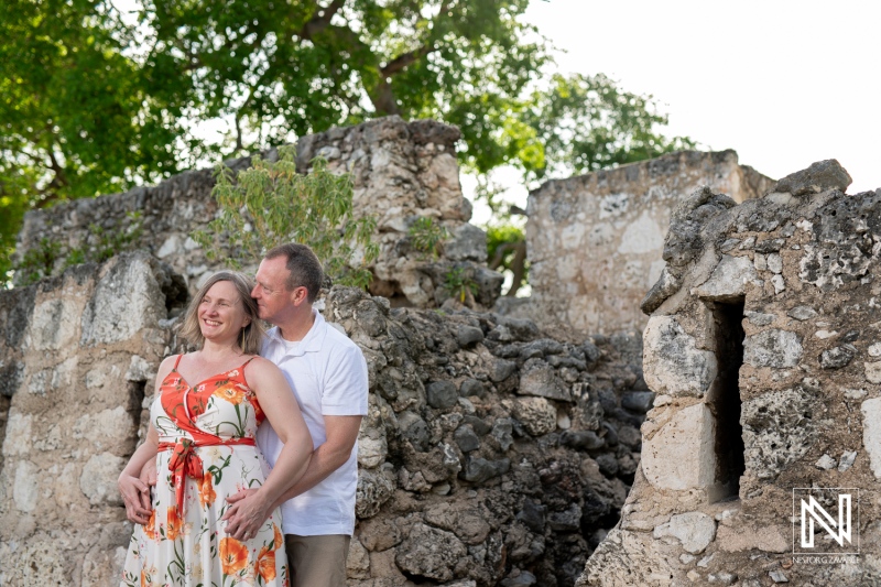 A Couple Enjoys a Sunny Day Near Ancient Ruins, Posing Together Amidst Weathered Stone Walls and Vibrant Greenery in a Serene Outdoor Setting