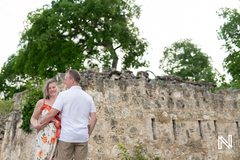 A Couple Enjoys a Romantic Moment Against Ancient Ruins in a Lush Green Park During a Sunny Afternoon