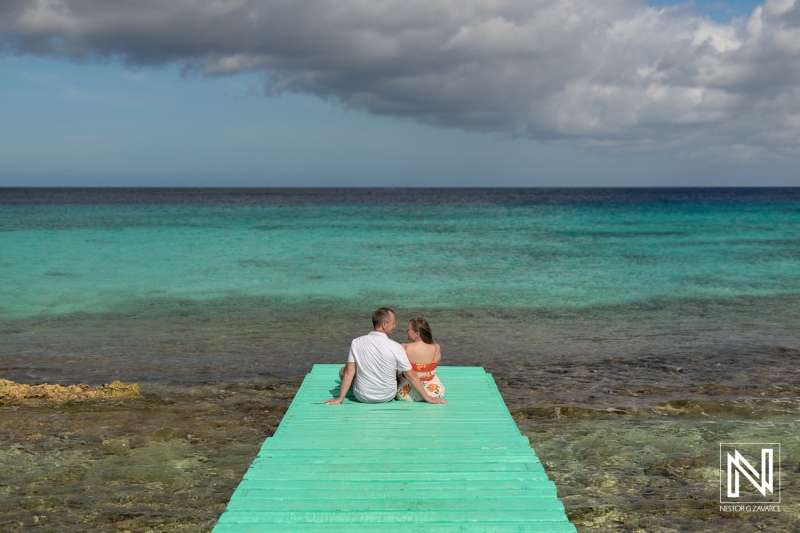 A Couple Enjoys a Tranquil Moment on a Turquoise Ocean Dock at Sunset in a Scenic Coastal Paradise