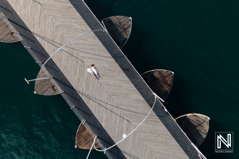 Couple enjoying a serene moment on a wooden pier at Queen Emma Bridge in Curacao