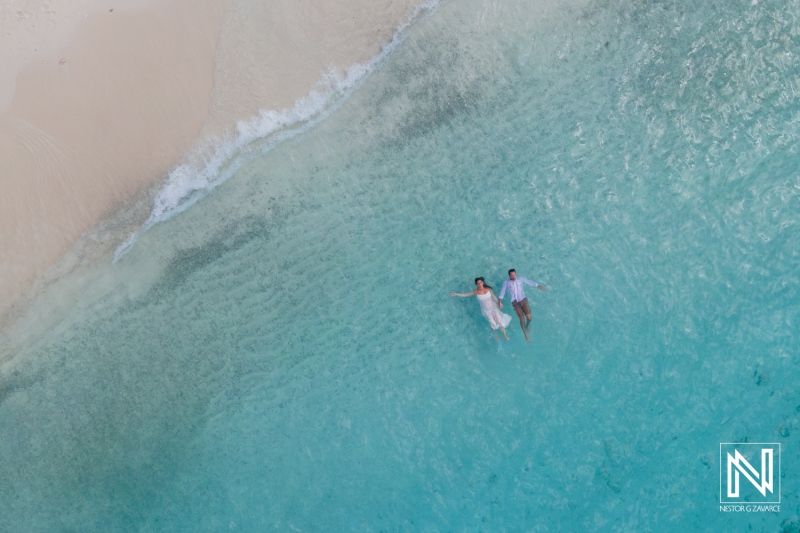 Couple enjoying a romantic moment while floating in the clear turquoise waters of Cas Abao Beach, Curacao during a sunny day