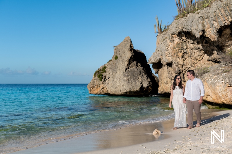 Couple walking hand in hand along the serene shores of Cas Abao Beach in Curacao on a sunny day