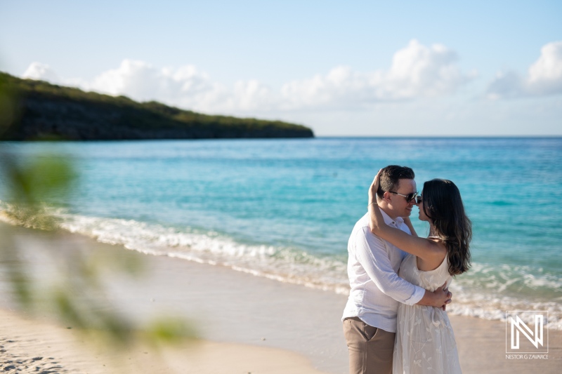 Couple embraces on Cas Abao Beach under the clear skies of Curacao during a romantic sunset moment