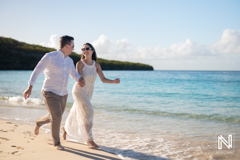 Couple enjoys a romantic walk along Cas Abao Beach in Curacao, capturing joyful moments under the sun and by the water