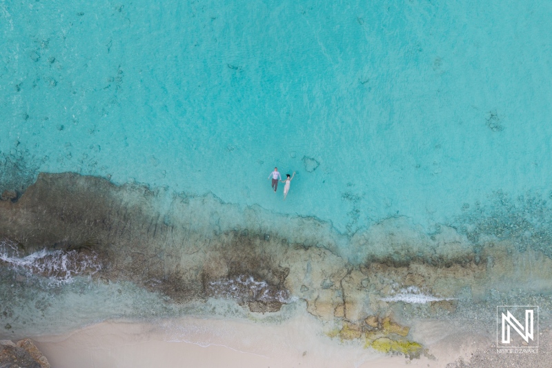 Couple enjoying a serene moment together in the crystal-clear waters of Cas Abao Beach in Curacao during a sunny day