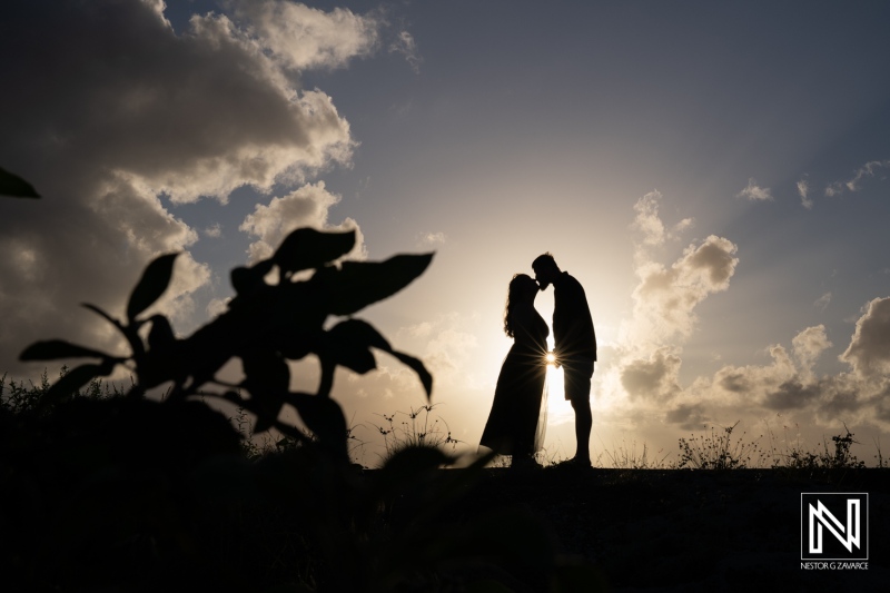 Couple shares a romantic moment during sunset in Curacao with a beautiful silhouette against the horizon
