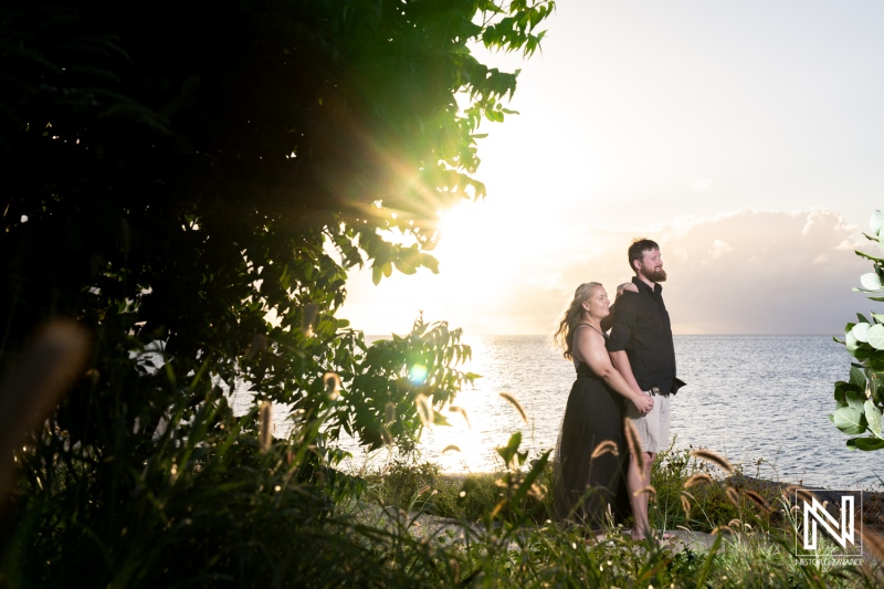 Couple enjoying a romantic evening overlooking the ocean in Curacao with the sun setting in the background