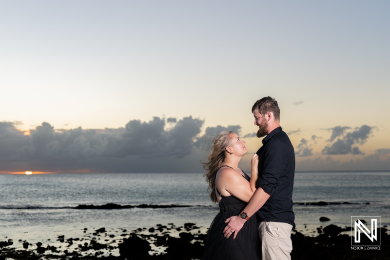 Couple enjoying a romantic moment at sunset on the beach in Curacao, surrounded by scenic ocean views and soft waves