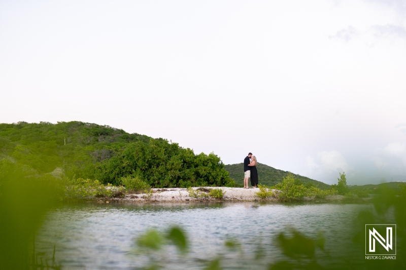 Couple enjoying a romantic moment by the serene waters in Curacao during a tranquil sunset