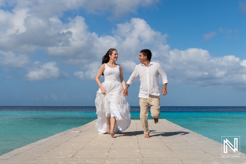 Couple enjoying a joyful sunrise stroll at Playa Porto Mari in Curacao, capturing love and beautiful moments together