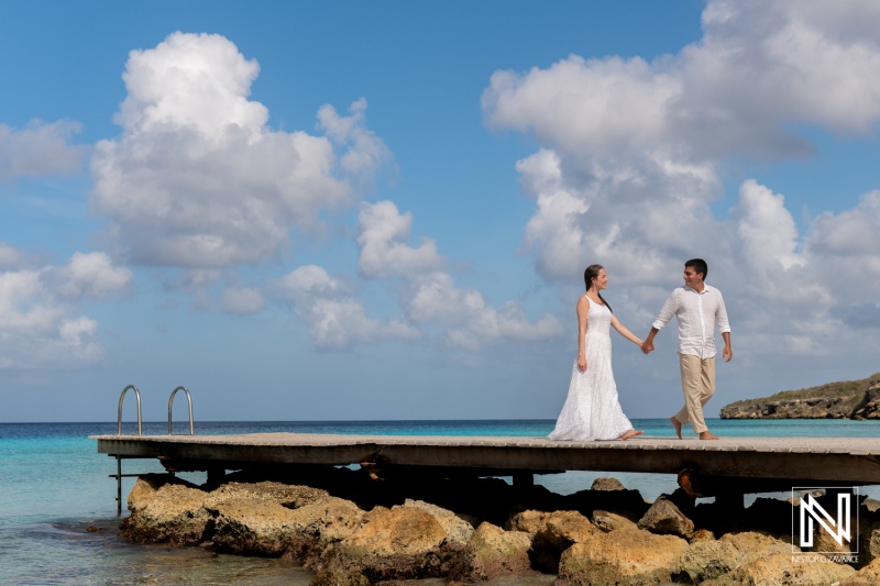 Couple enjoys a romantic morning stroll on the pier at Playa Porto Mari, Curacao during sunrise, capturing beautiful memories together