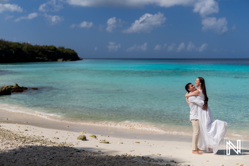 Couple enjoying a romantic sunrise together at Playa Porto Mari in Curacao, creating lasting memories amidst beautiful coastal scenery