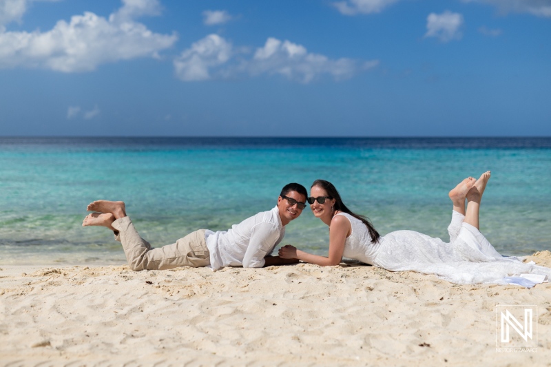 Couple enjoys sunrise photoshoot at Playa Porto Mari in Curacao with vibrant sea and sandy beach backdrop