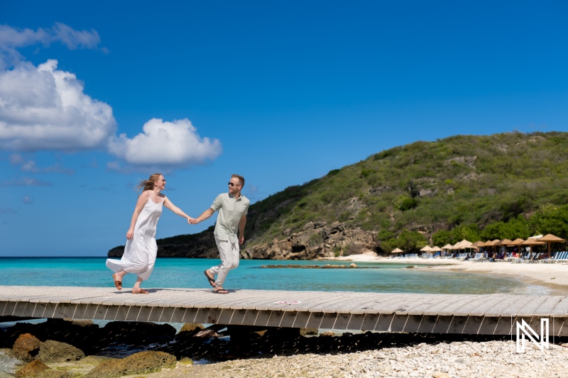 Couple enjoying a romantic stroll along the boardwalk at Playa Porto Mari in Curacao on a sunny day