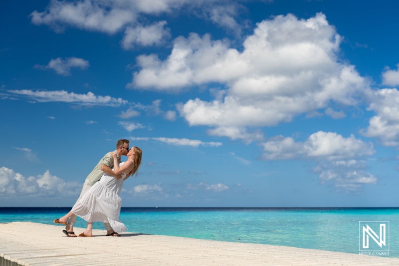 Couple embraces on the shores of Playa Porto Mari in Curacao under a bright blue sky