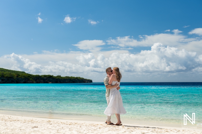 Couple enjoys a romantic moment on the beach at Playa Porto Mari in Curacao under a bright blue sky