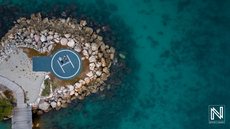 Couple enjoys photoshoot at Baoase Luxury Resort in Curacao on a rocky area by the turquoise water