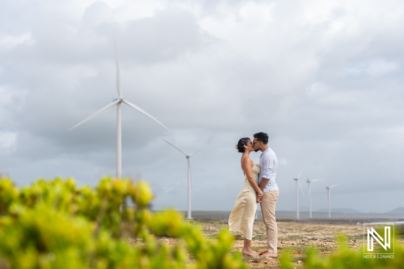 Engagement session at Vlakte di San Pedro in Curacao with couple enjoying a romantic moment among wind turbines