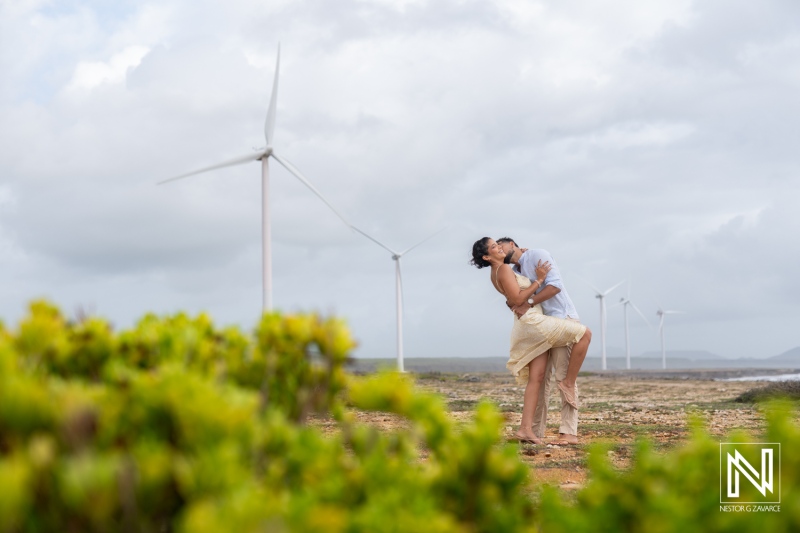 Engagement session capturing love at Vlakte di San Pedro in Curacao with wind turbines in the background