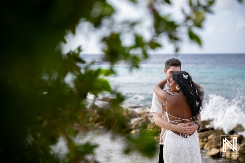 Couple enjoys engagement session at Marie Pampoen beach in Curacao during a sunny day by the water