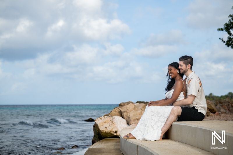 Engagement session at Marie Pampoen beach in Curacao during a sunny afternoon with a couple sitting by the water