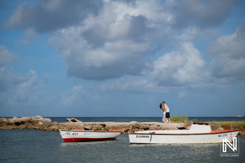 Couple engages in a romantic moment at Marie Pampoen beach in Curacao during a sunny day by the water