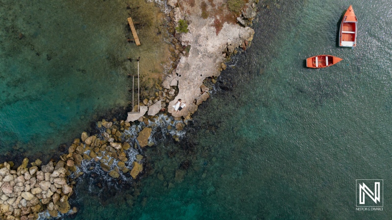 Engagement session takes place at Marie Pampoen in Curacao near the water with boats nearby