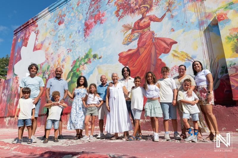 Family gathering in front of vibrant mural in Curacao during sunny afternoon