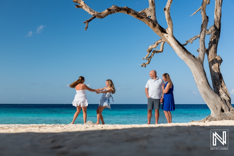 Family and friends enjoy a joyful beach day in Curacao under the warm sun and clear blue skies with laughter and playful dancing