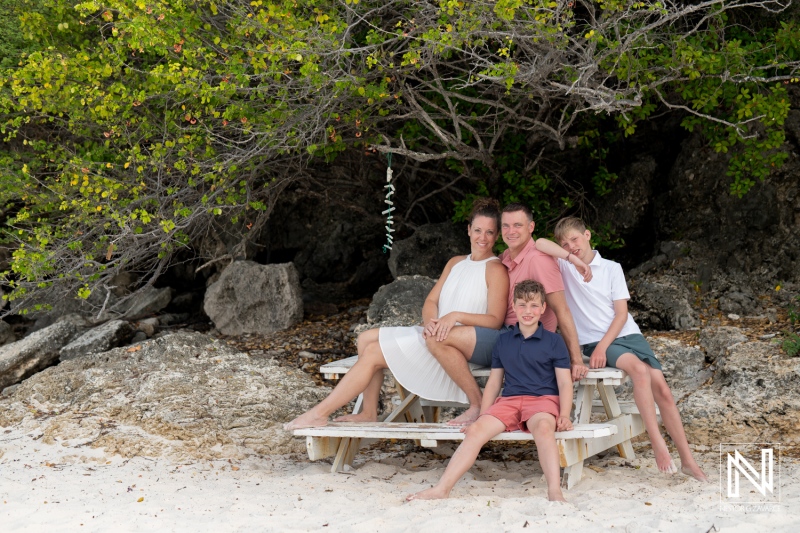 Family and friends enjoy a joyful photoshoot at a beautiful beach in Curacao surrounded by lush greenery and soft white sand
