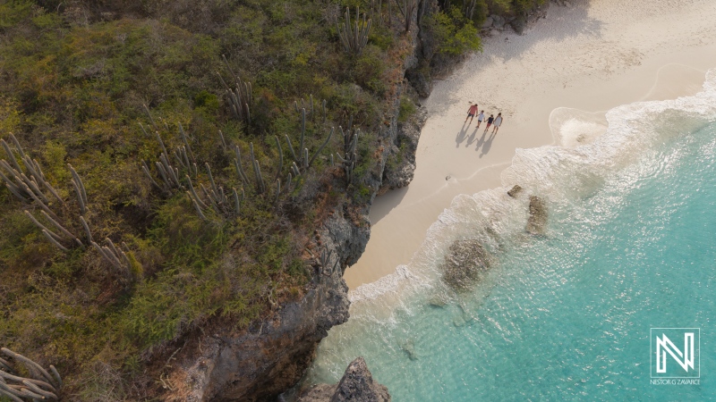 Family and friends gather for a joyful photoshoot on a beautiful beach in Curacao during sunny weather